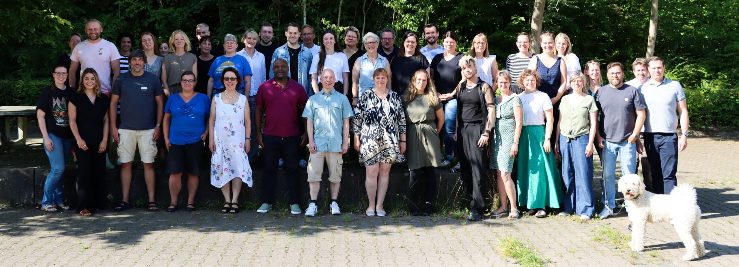 Bild vom Kollegium der Lisa-Tetzner-Schule bei Sonnenschein im Schulhof